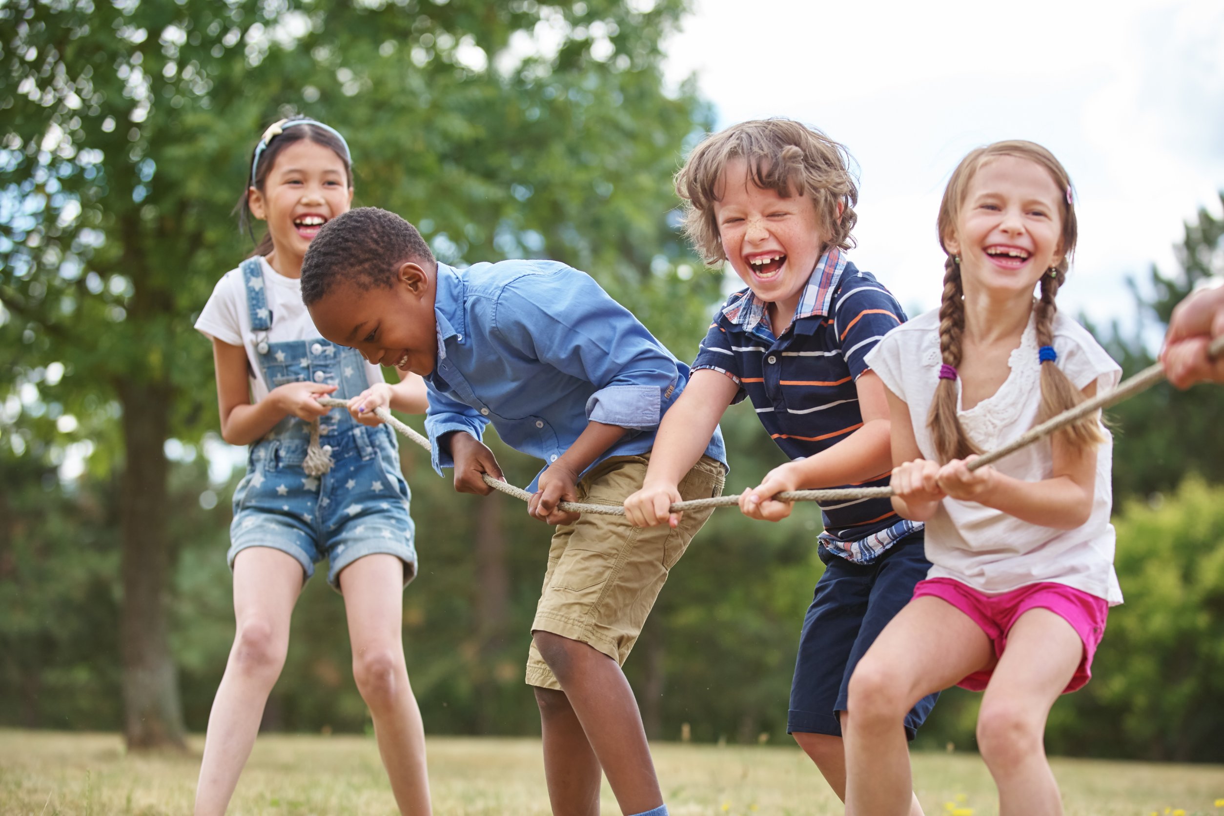 children playing tug of war, all smiling